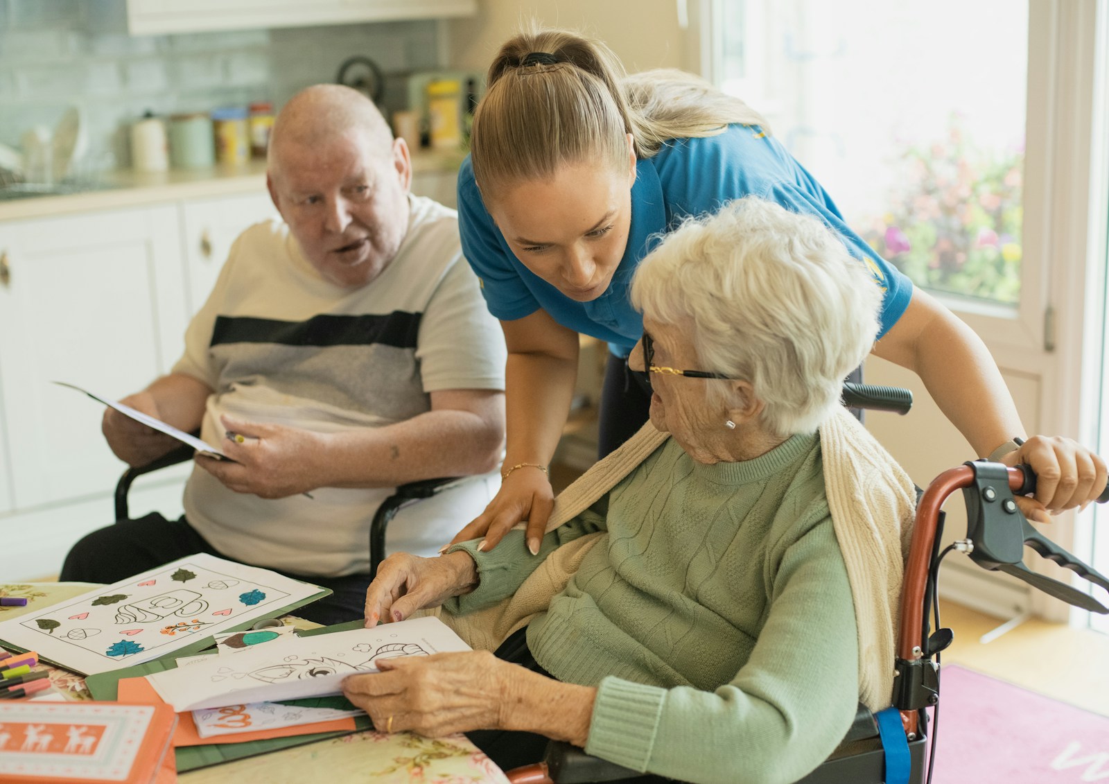 A carer supporting an elderly couple together at home