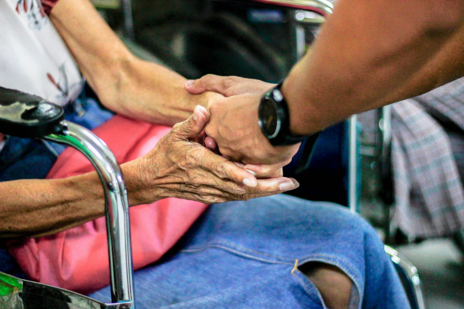 A carer gently holding an elderly client's hand, offering comfort and support